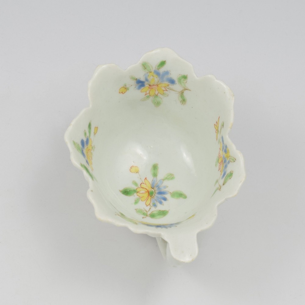 An eighteenth-century Dr Wall First Period Worcester soft-paste porcelain butter boat featuring hand-painted polychrome floral enamel sprigs and a leaf-moulded rim. View III