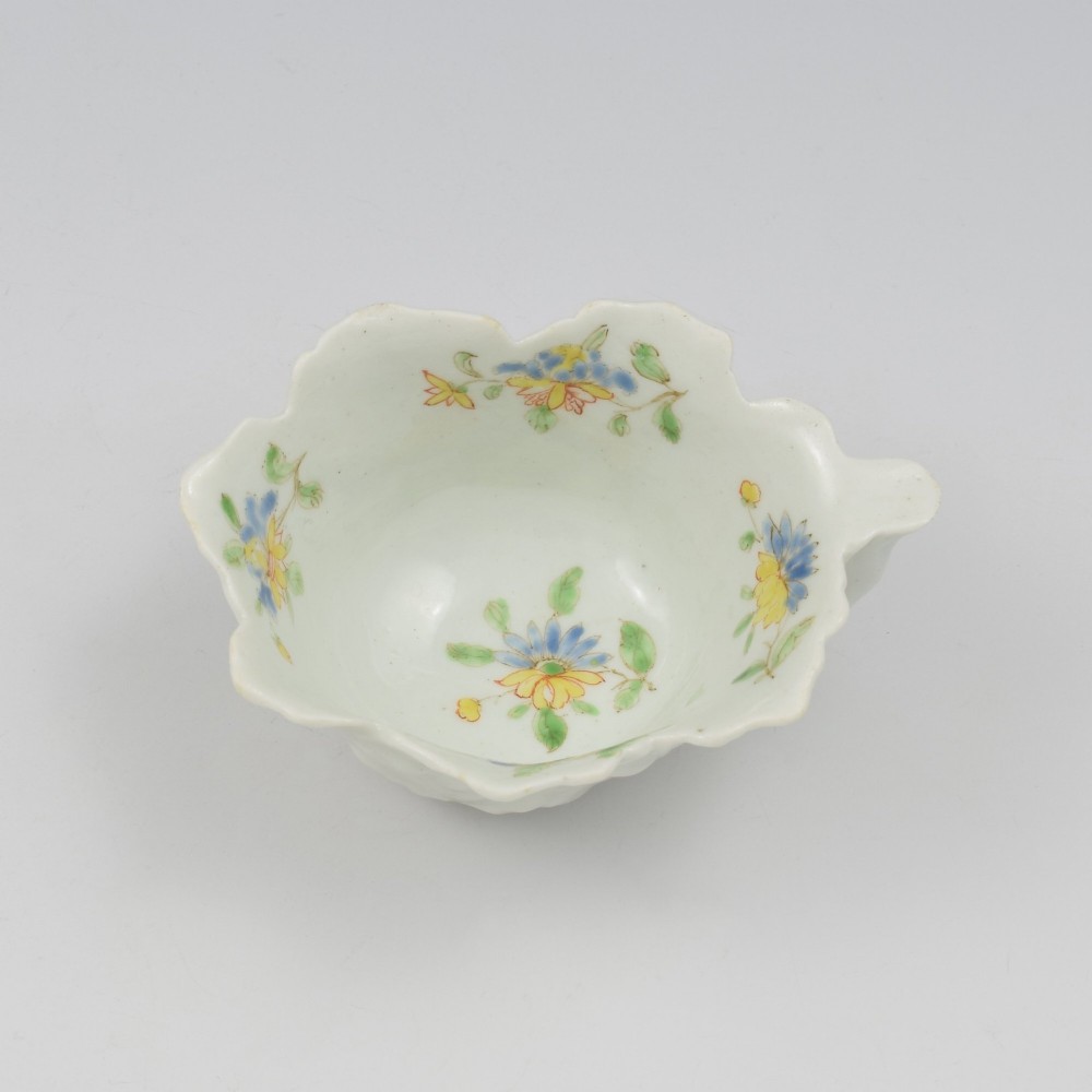 An eighteenth-century Dr Wall First Period Worcester soft-paste porcelain butter boat featuring hand-painted polychrome floral enamel sprigs and a leaf-moulded rim. View IV