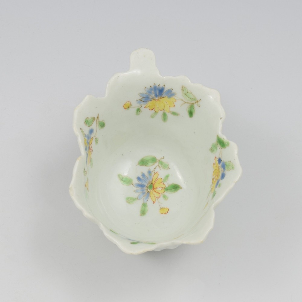 An eighteenth-century Dr Wall First Period Worcester soft-paste porcelain butter boat featuring hand-painted polychrome floral enamel sprigs and a leaf-moulded rim. View V