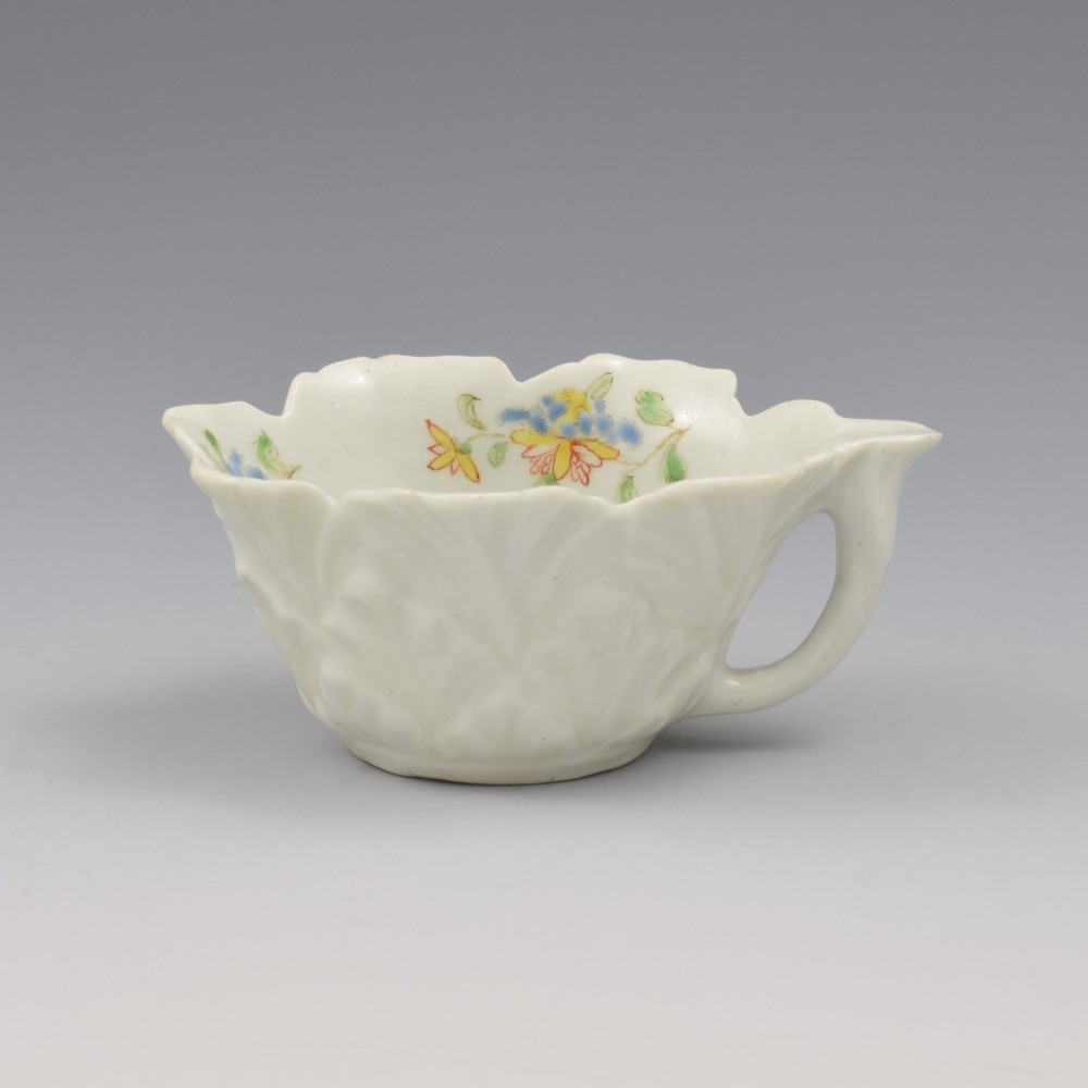 An eighteenth-century Dr Wall First Period Worcester soft-paste porcelain butter boat featuring hand-painted polychrome floral enamel sprigs and a leaf-moulded rim. View VII