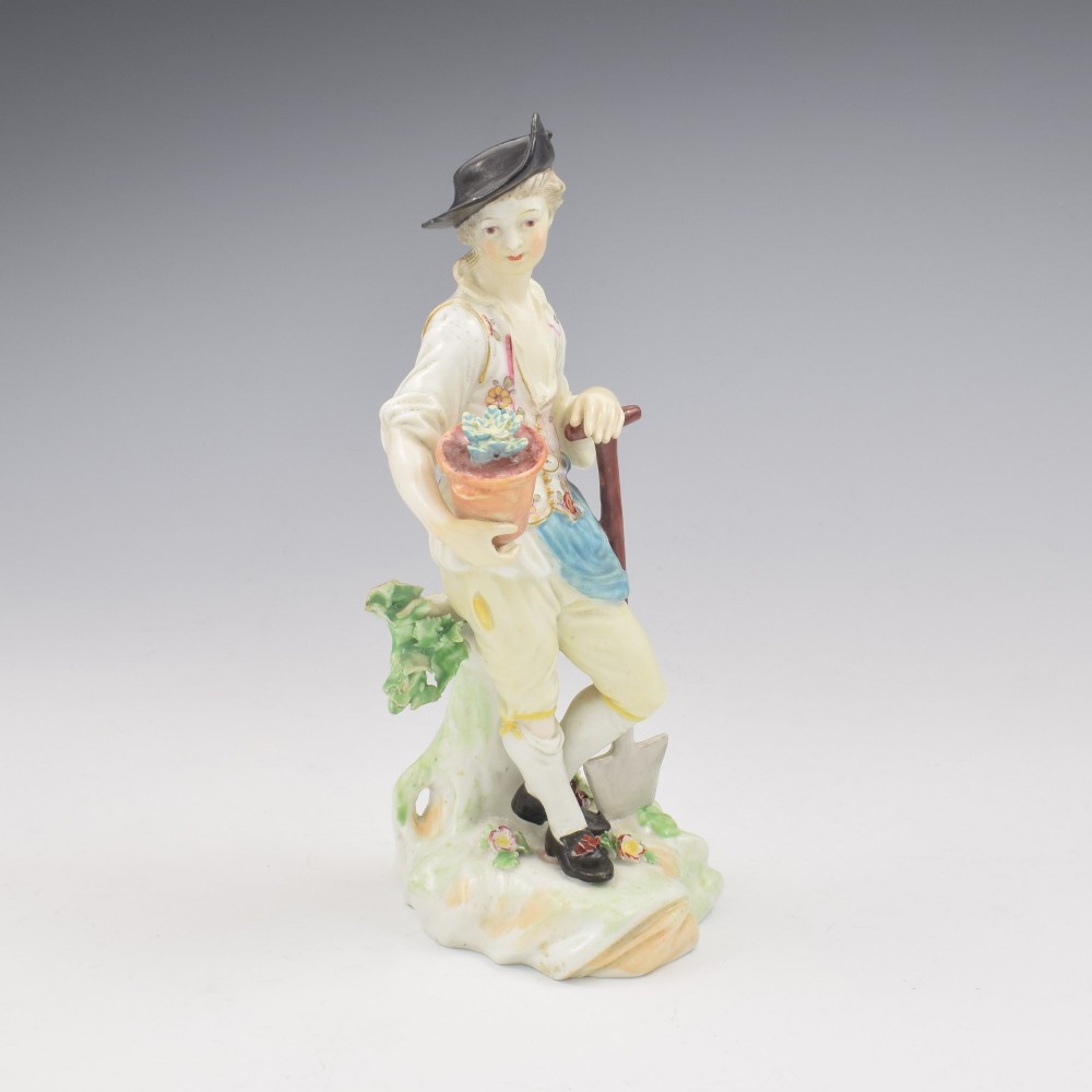An 18th-century Derby porcelain figurine depicting a gardener holding a flower pot and leaning on a spade. View II