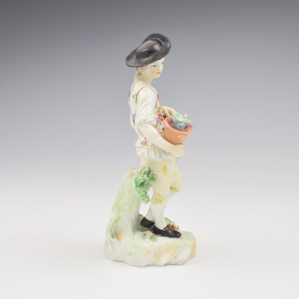An 18th-century Derby porcelain figurine depicting a gardener holding a flower pot and leaning on a spade. View III