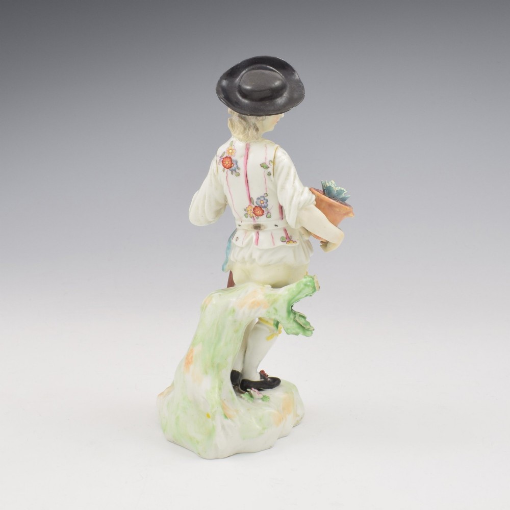 An 18th-century Derby porcelain figurine depicting a gardener holding a flower pot and leaning on a spade. View IV