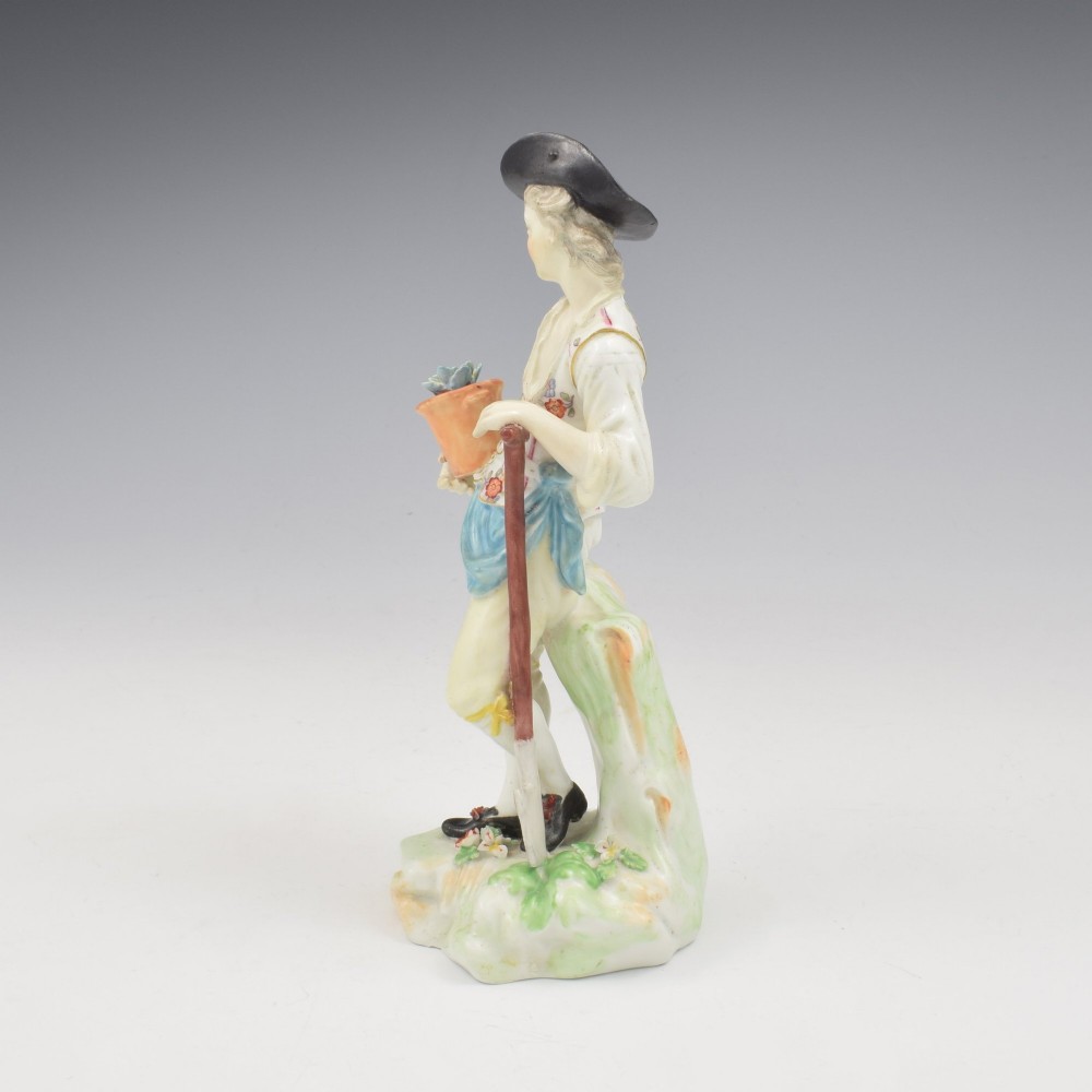An 18th-century Derby porcelain figurine depicting a gardener holding a flower pot and leaning on a spade. View VII