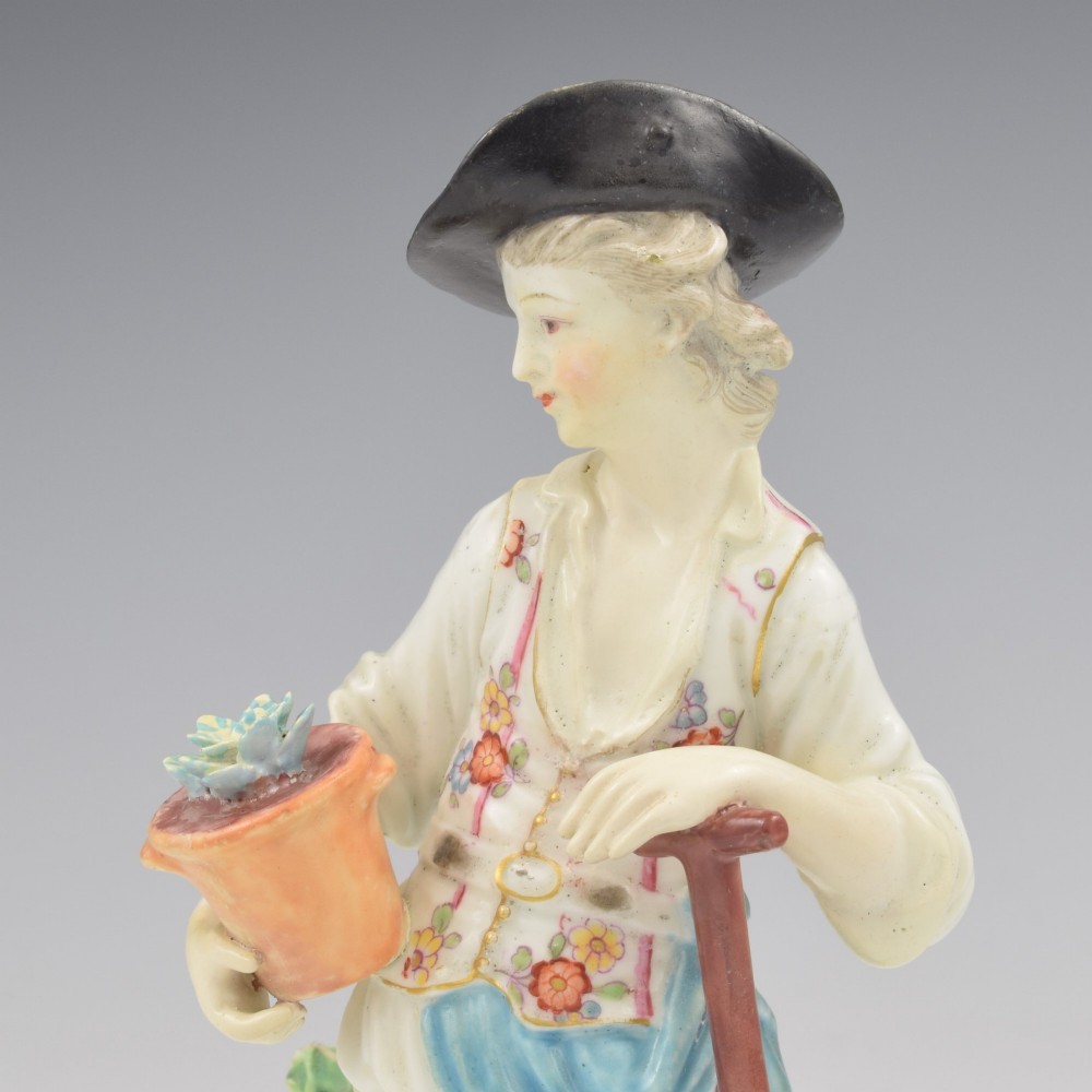 An 18th-century Derby porcelain figurine depicting a gardener holding a flower pot and leaning on a spade. View IX