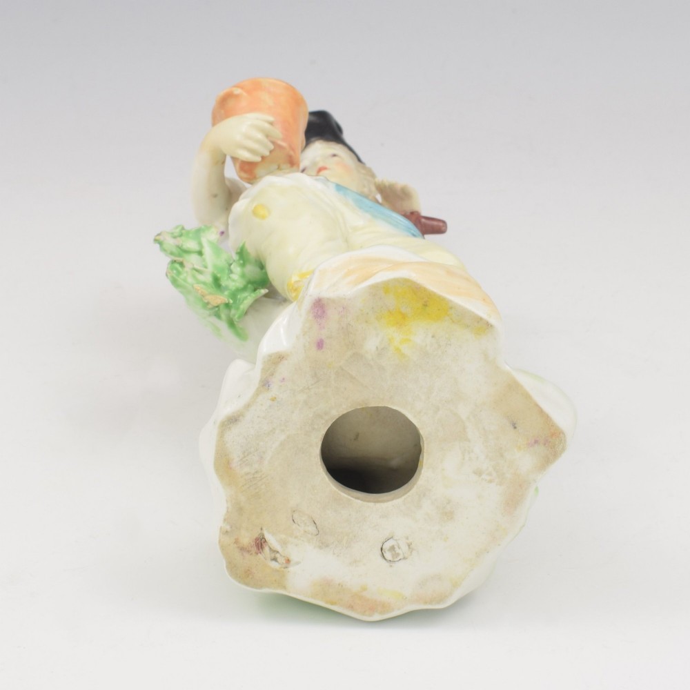 An 18th-century Derby porcelain figurine depicting a gardener holding a flower pot and leaning on a spade. View XI