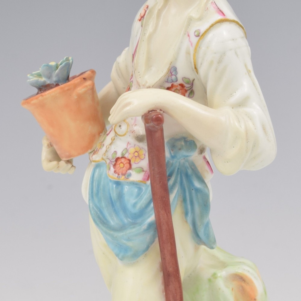 An 18th-century Derby porcelain figurine depicting a gardener holding a flower pot and leaning on a spade. View XIV