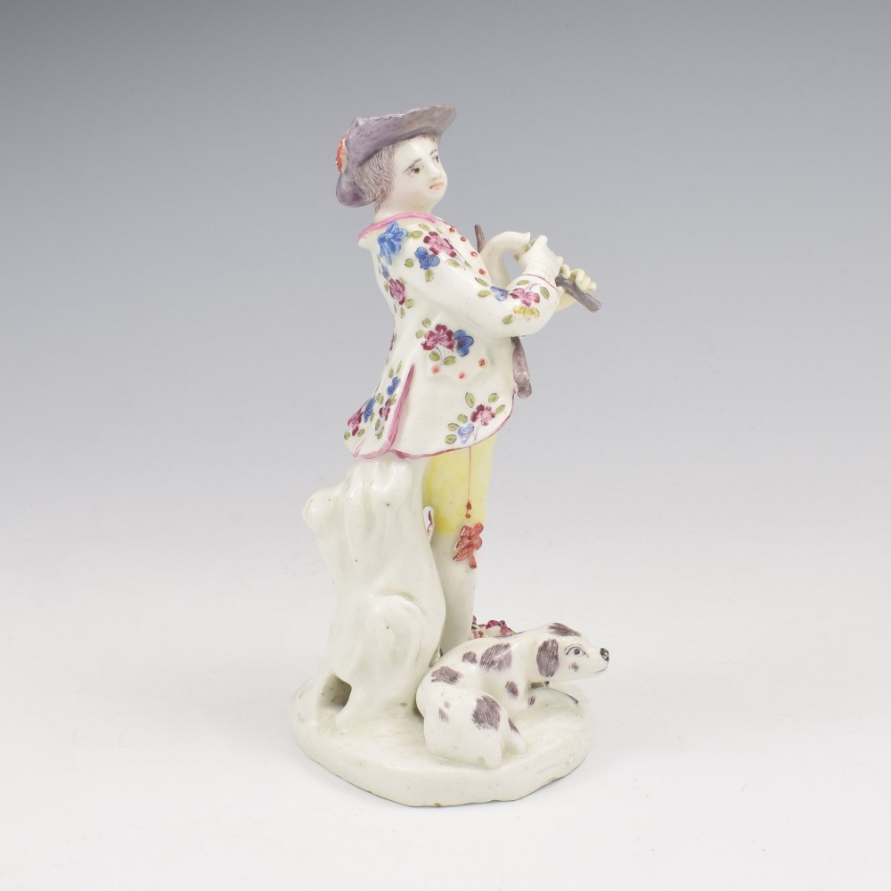 An eighteenth-century Bow porcelain figurine depicting a young shepherd playing a pipe alongside a small dog on a sculpted base. View III