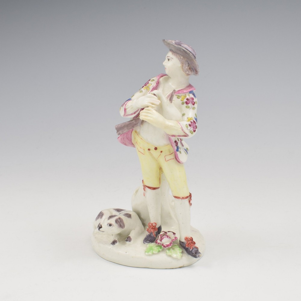 An eighteenth-century Bow porcelain figurine depicting a young shepherd playing a pipe alongside a small dog on a sculpted base. View VIII