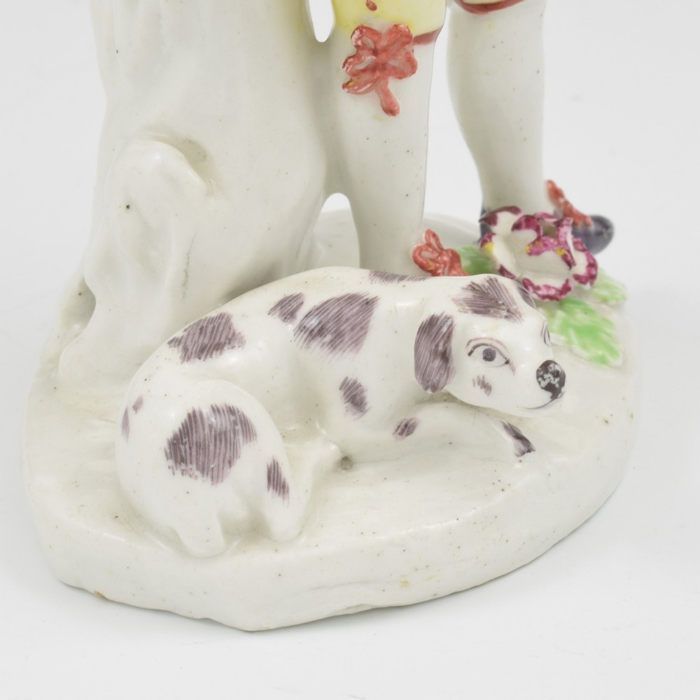 An eighteenth-century Bow porcelain figurine depicting a young shepherd playing a pipe alongside a small dog on a sculpted base. View XI