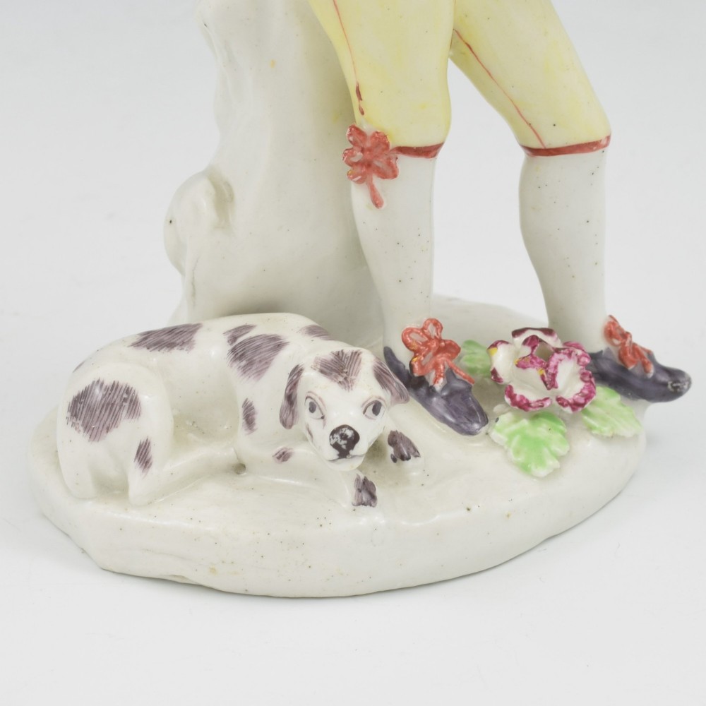 An eighteenth-century Bow porcelain figurine depicting a young shepherd playing a pipe alongside a small dog on a sculpted base. View XIII