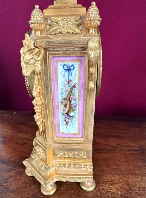 fig 1. A late 19th-century French gilt bronze mantel clock featuring pink hand-painted porcelain panels and an urn finial.
