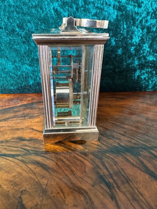 fig 1. A rectangular brass carriage clock featuring bevelled glass side panels, a top handle, and a white enamel dial with Roman numerals marked Mappin & Webb London.