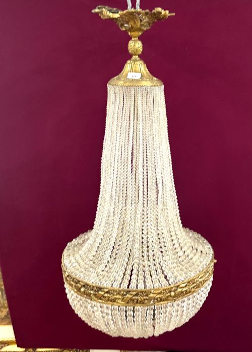 fig 1. A French Empire style crystal basket chandelier featuring cascading glass bead strands and a chased gilt-bronze ornamental ring.