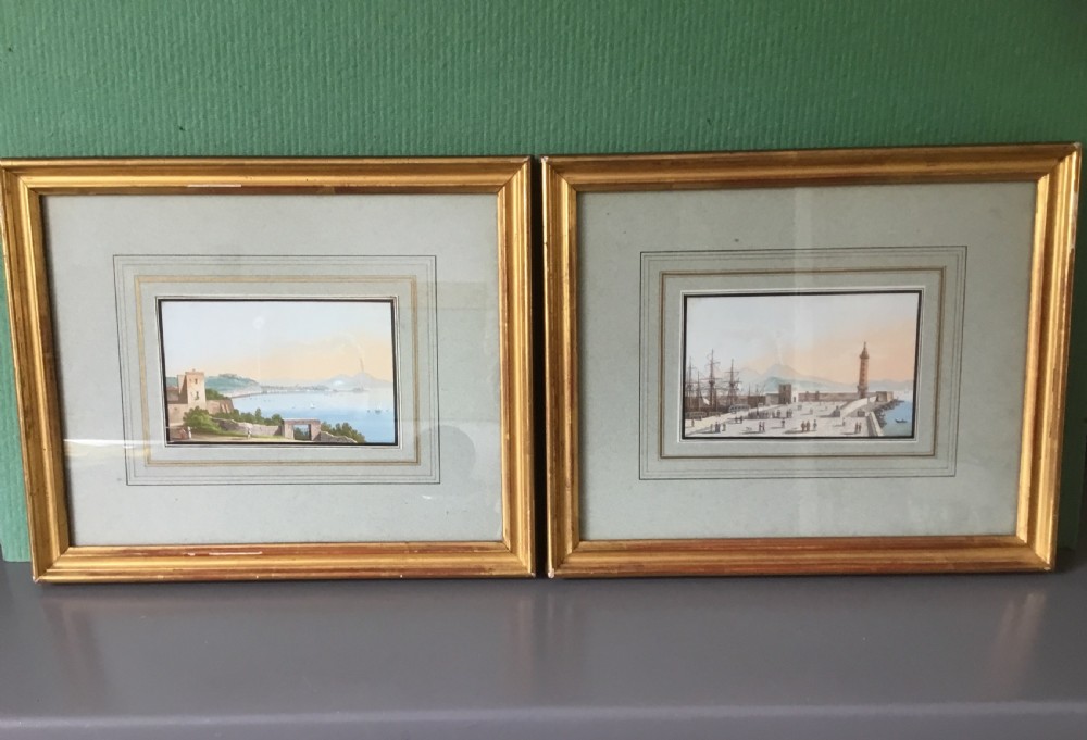 A pair of nineteenth-century framed gouache paintings depicting coastal Neapolitan harbour scenes set in gilt wood frames.