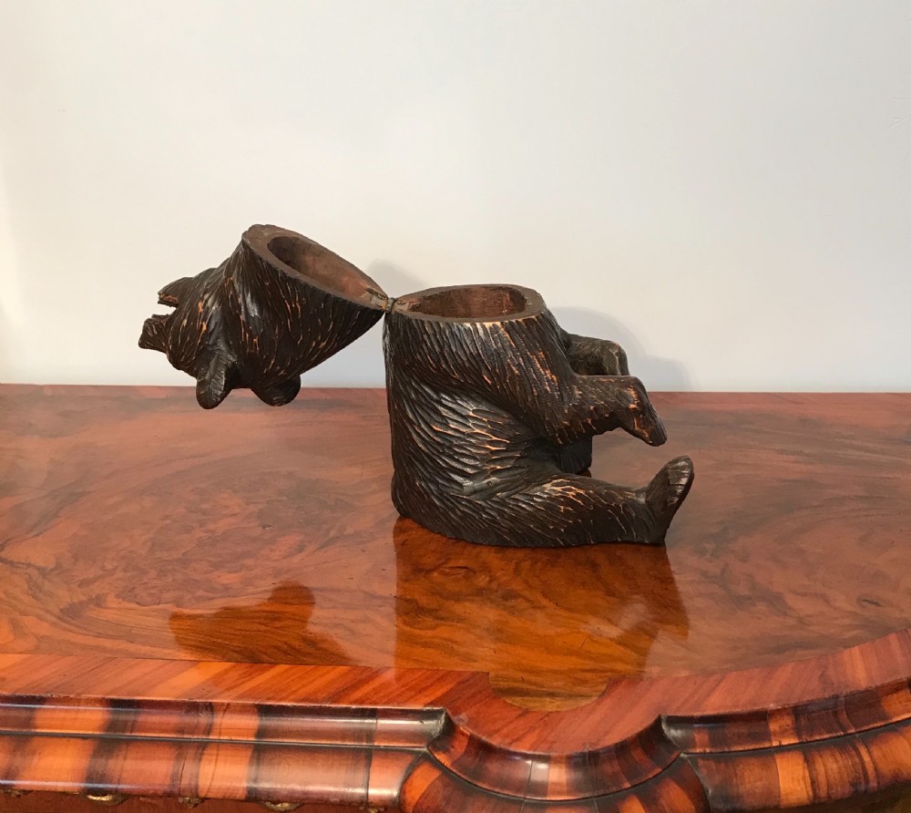 A hand-carved dark wood sitting bear figurine in the Black Forest style with textured fur and an open mouth. View V
