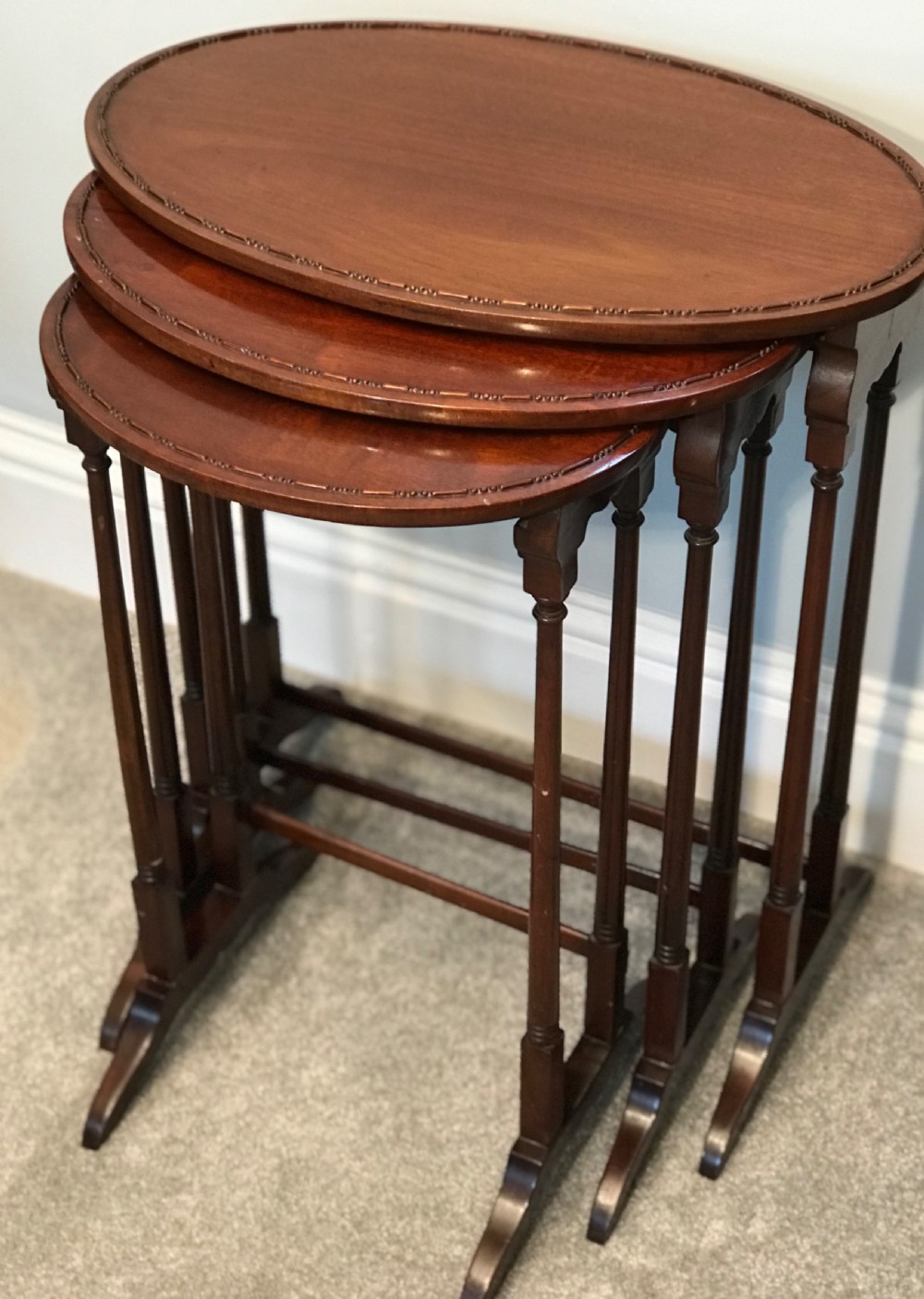 A set of three graduating oval mahogany side tables with carved beaded rims and slender turned legs. View II