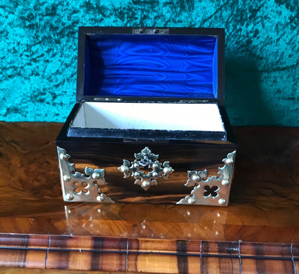 A Victorian dome-topped wooden box crafted from dark timber featuring decorative pierced brass strapwork and a key inserted in the lock. View VI