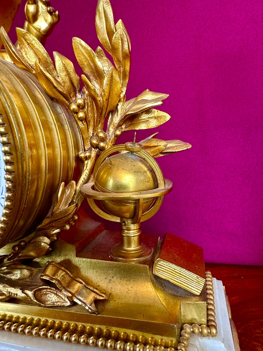 A late 19th-century three-piece French ormolu and white marble clock garniture set featuring a central putto-adorned mantel clock flanked by matching three-light candelabra. View VII