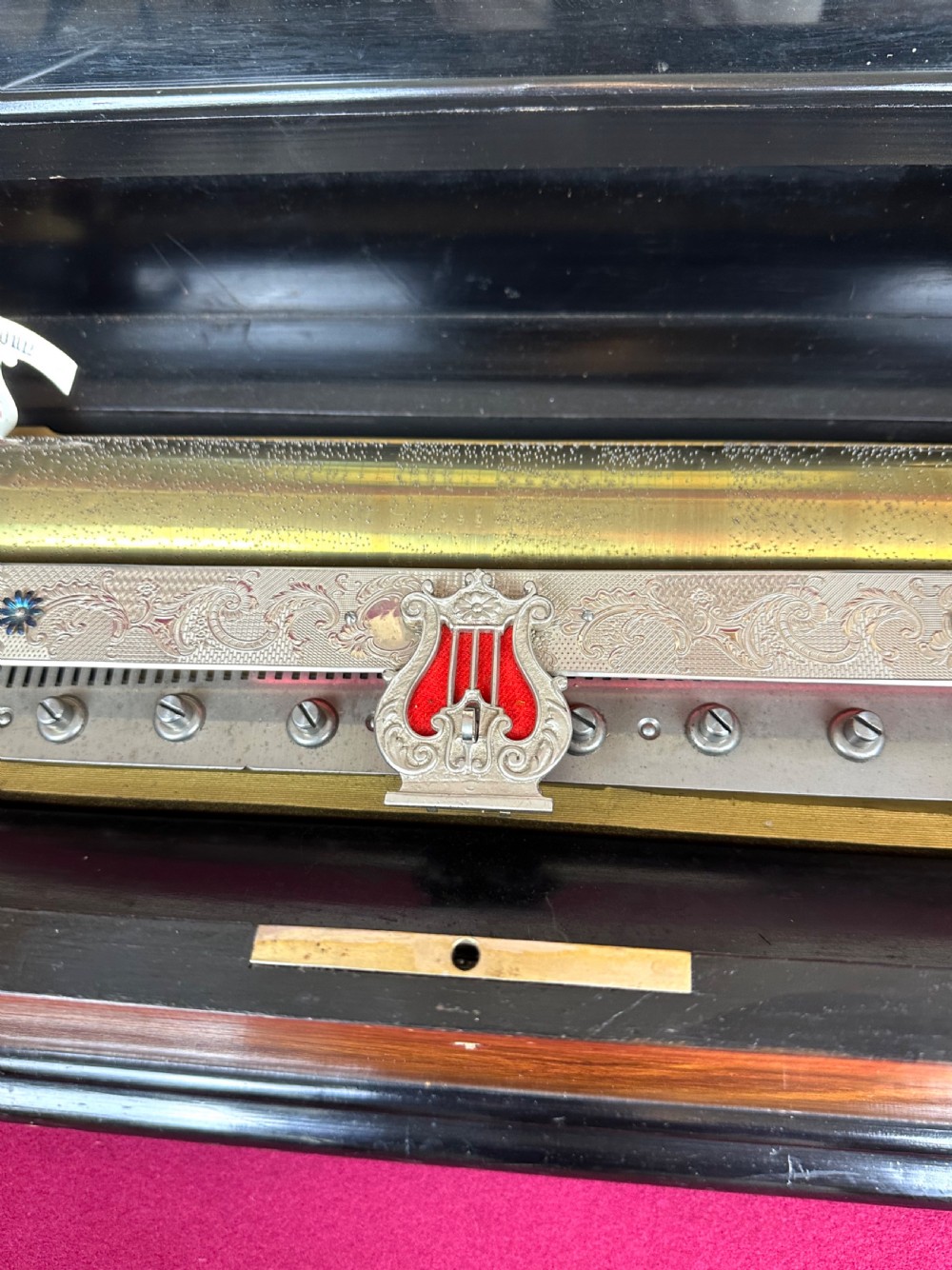 A rectangular Victorian wooden music box featuring floral iris marquetry inlaid on the lid with ebonised moulded borders. View V