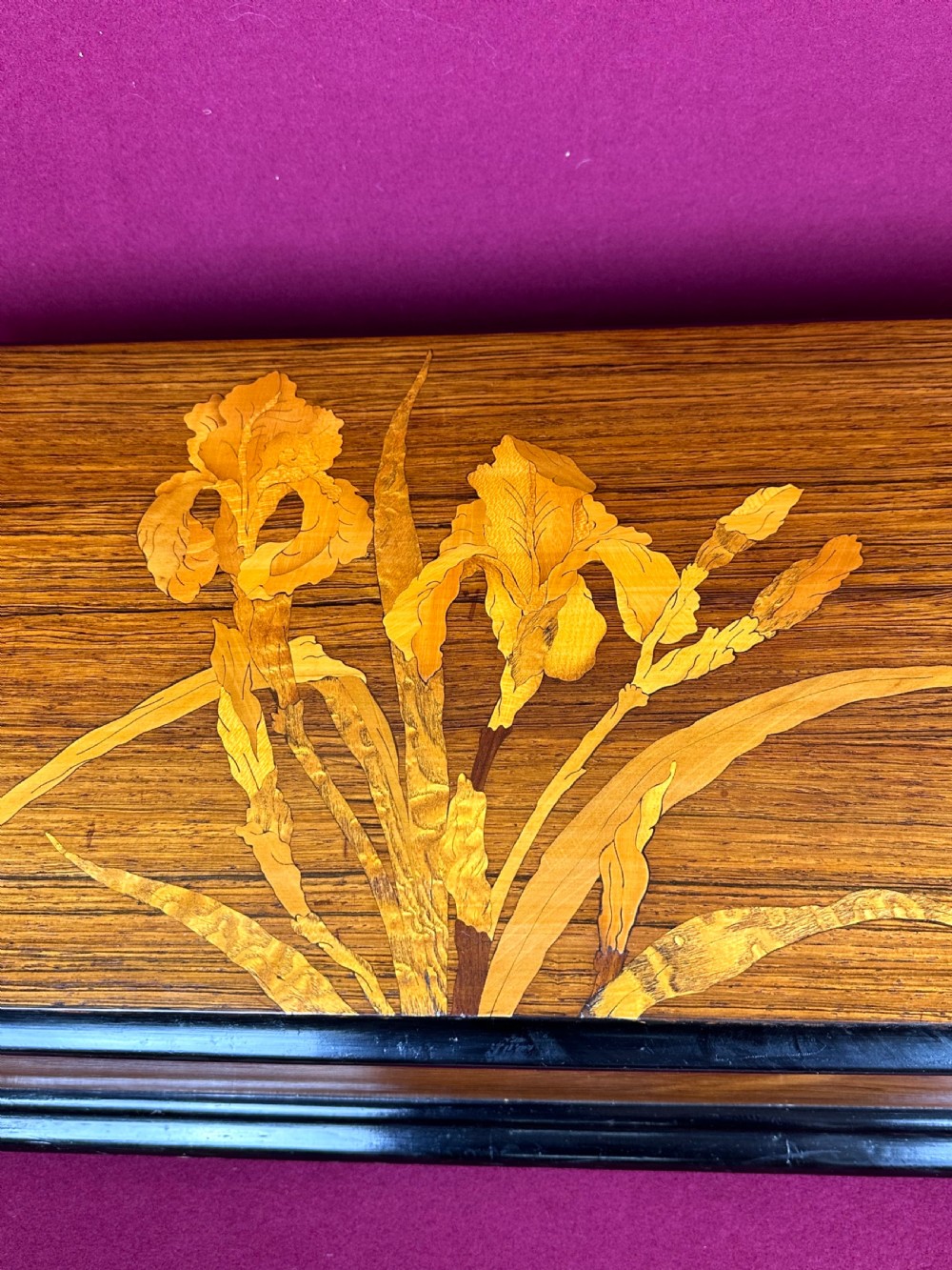 A rectangular Victorian wooden music box featuring floral iris marquetry inlaid on the lid with ebonised moulded borders. View IX