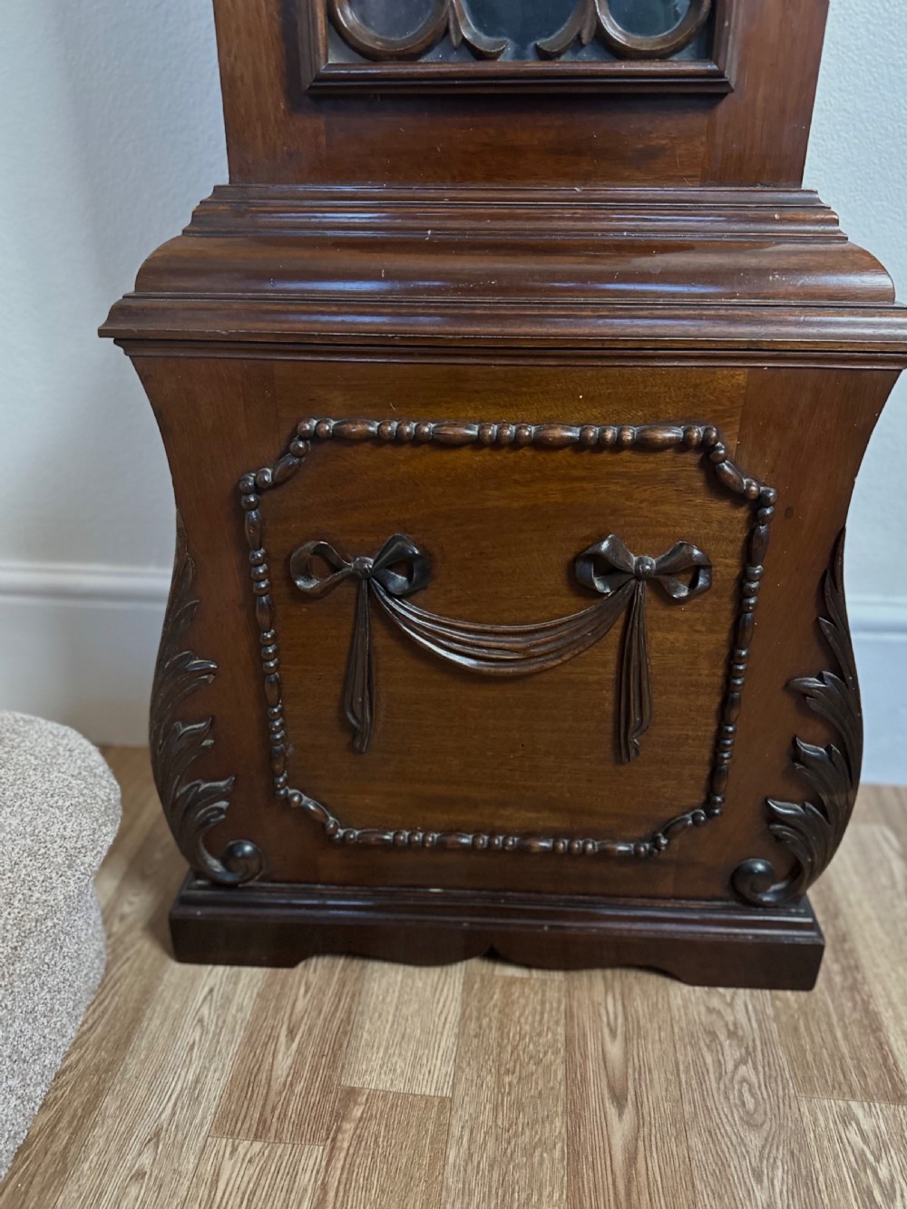 A carved mahogany longcase clock featuring an ornate brass dial, scrolled pediment with a Tempus Fugit plaque, and decorative wood tracery glass panel. View IV