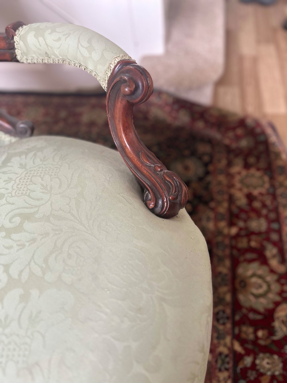A pair of late Victorian carved mahogany salon armchairs upholstered in light green damask fabric featuring cabriole legs and scroll arms. View VI
