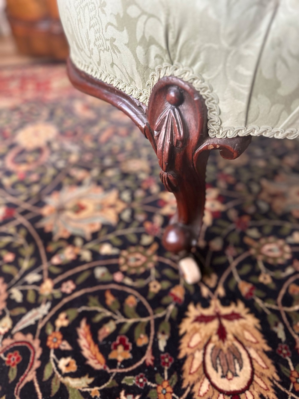 A pair of late Victorian carved mahogany salon armchairs upholstered in light green damask fabric featuring cabriole legs and scroll arms. View VII