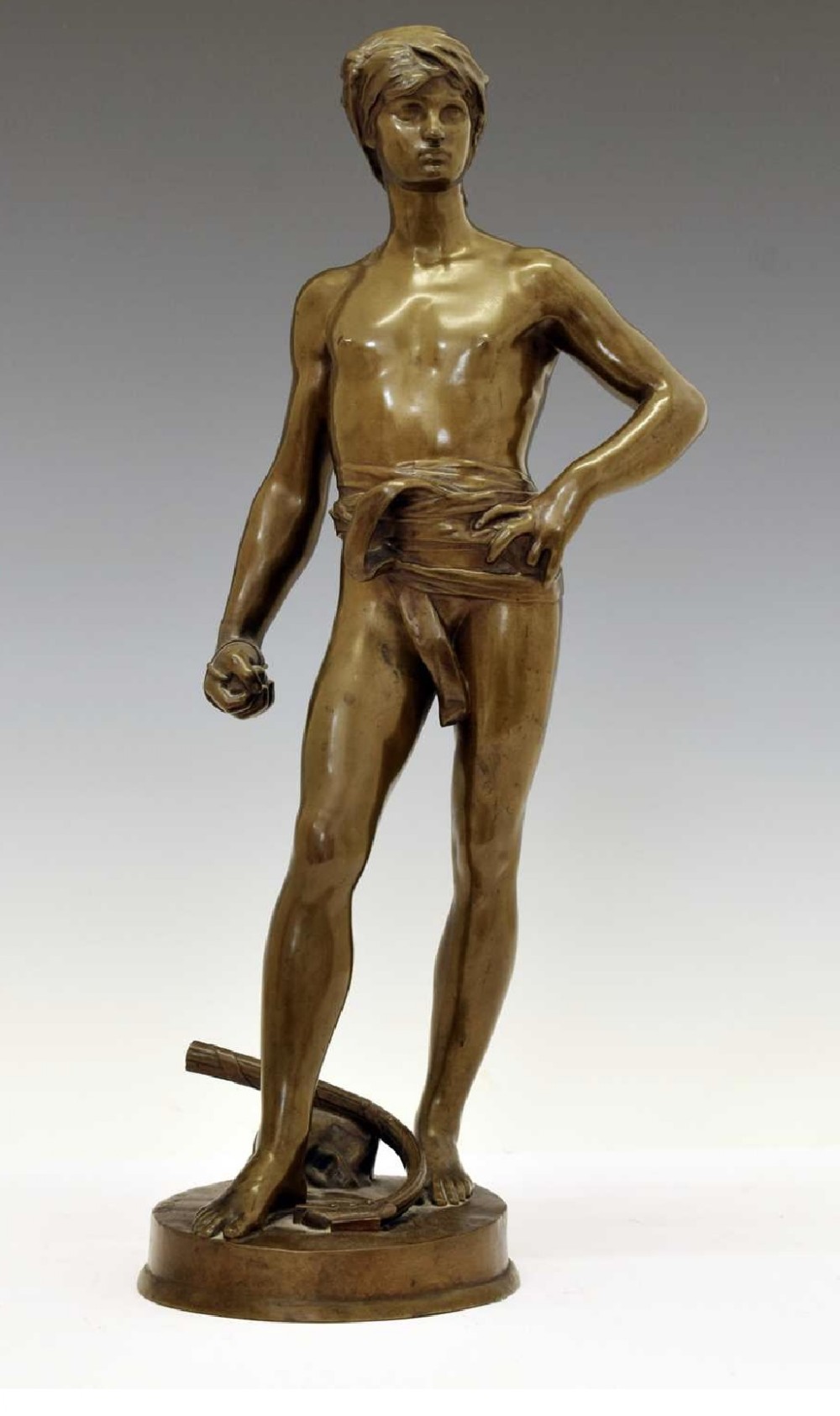 A 19th-century patinated bronze sculpture depicting the youth David standing in a contrapposto pose with a headwear turban on a round base.