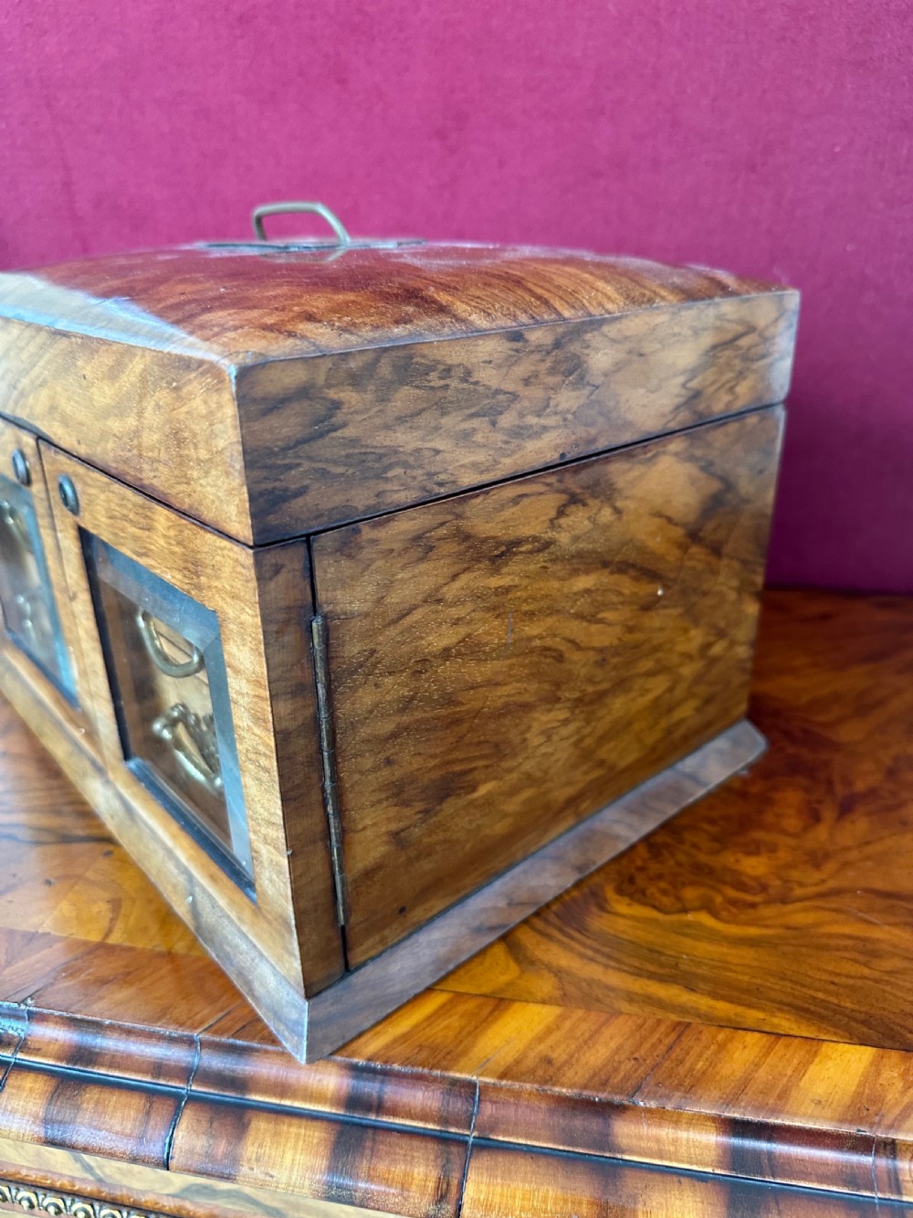 An open late Victorian walnut jewellery and sewing box featuring a green tufted silk lid lining with an oval mirror, top storage section, and two lower drawers behind glass doors. View III