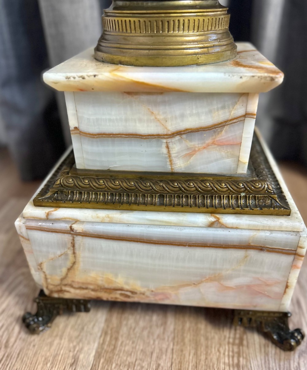 A tall cream-toned banded onyx column featuring a gilt bronze Corinthian capital, a square top plate, and a stepped square base. View VII