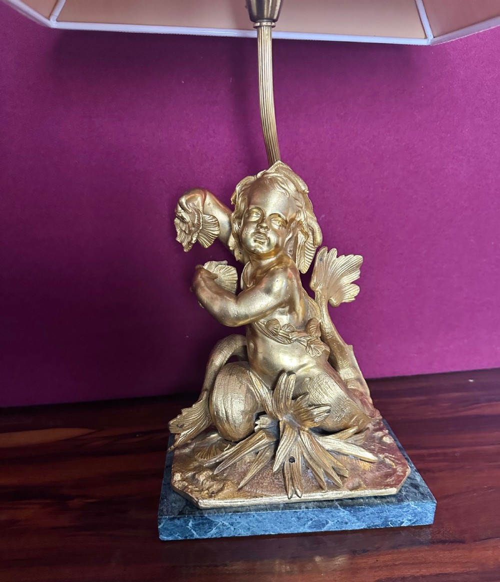 A pair of late nineteenth-century French ormolu table lamps featuring cast bronze cherub figures mounted on marble bases with soft pink fabric shades. View VI
