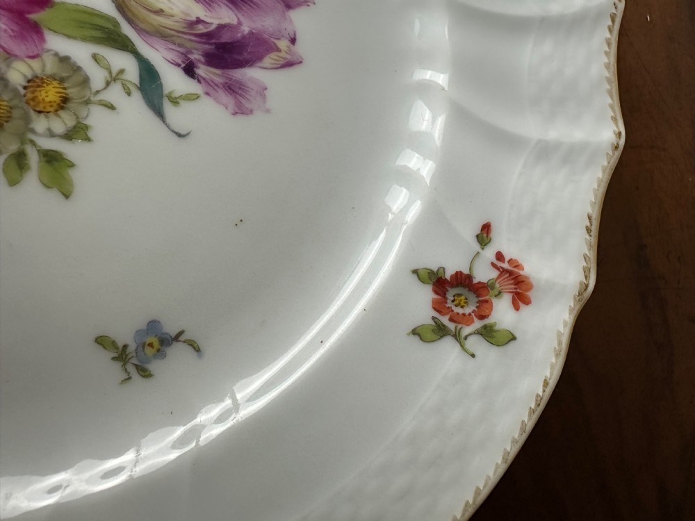 A pair of round white porcelain plates featuring hand-painted botanical flowers with scalloped edges. View III