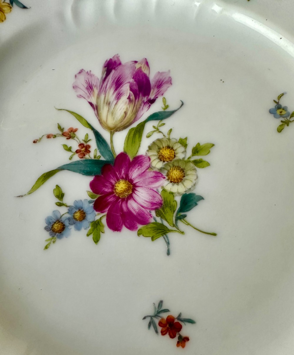 A pair of round white porcelain plates featuring hand-painted botanical flowers with scalloped edges. View V