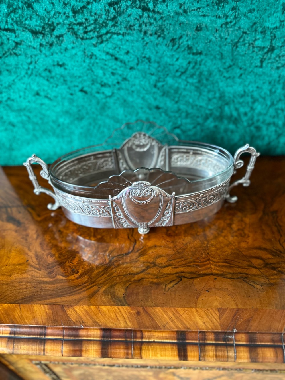 An oblong silver-plated Art Nouveau centrepiece bowl featuring ornate twin handles, relief scrollwork, a central cartouche, and a clear glass liner. View VII