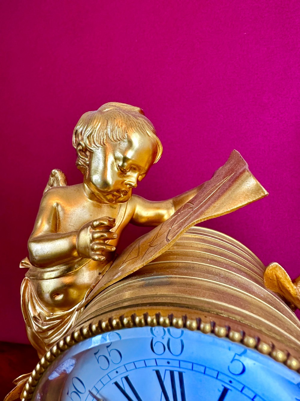 A 19th-century French gilt bronze and white marble clock garniture set comprising a central clock with a cherub motif and two flanking three-light candelabras. View VI