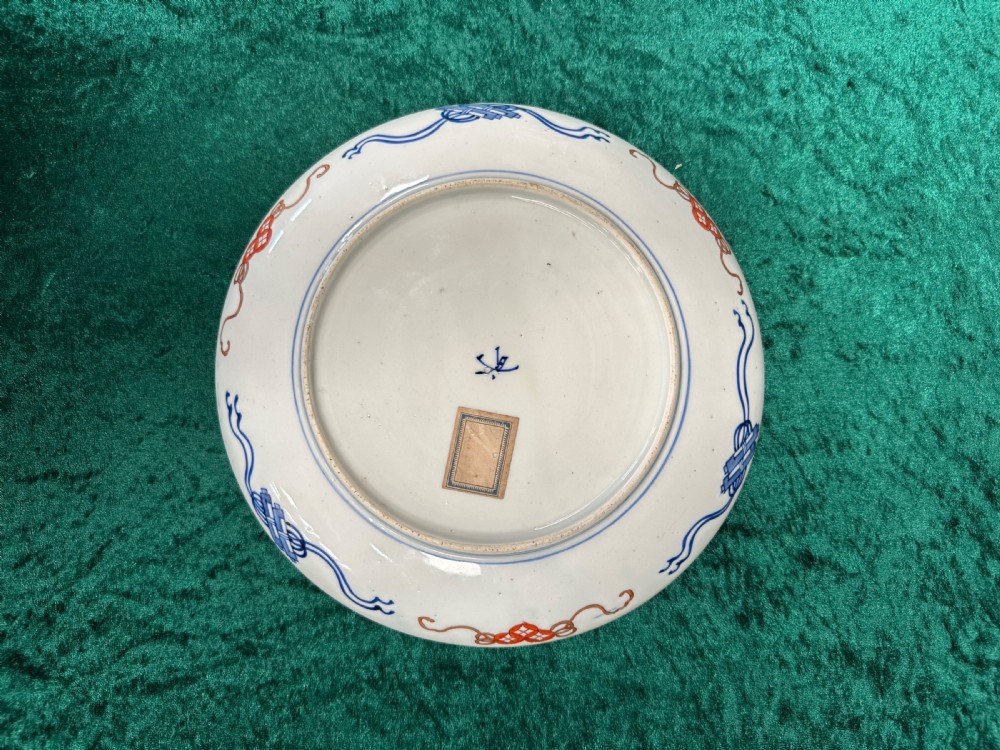 A circular Japanese Imari porcelain plate decorated in cobalt blue, iron-red, and gold accents around panels featuring phoenixes and blossom trees. View VII