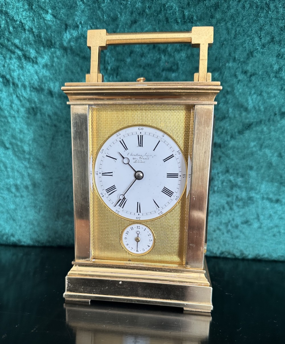 A late 19th-century gilt brass French carriage clock featuring a rectangular case, top carrying handle, glass panels revealing internal gears, and a white enamel dial with Roman numerals. View III