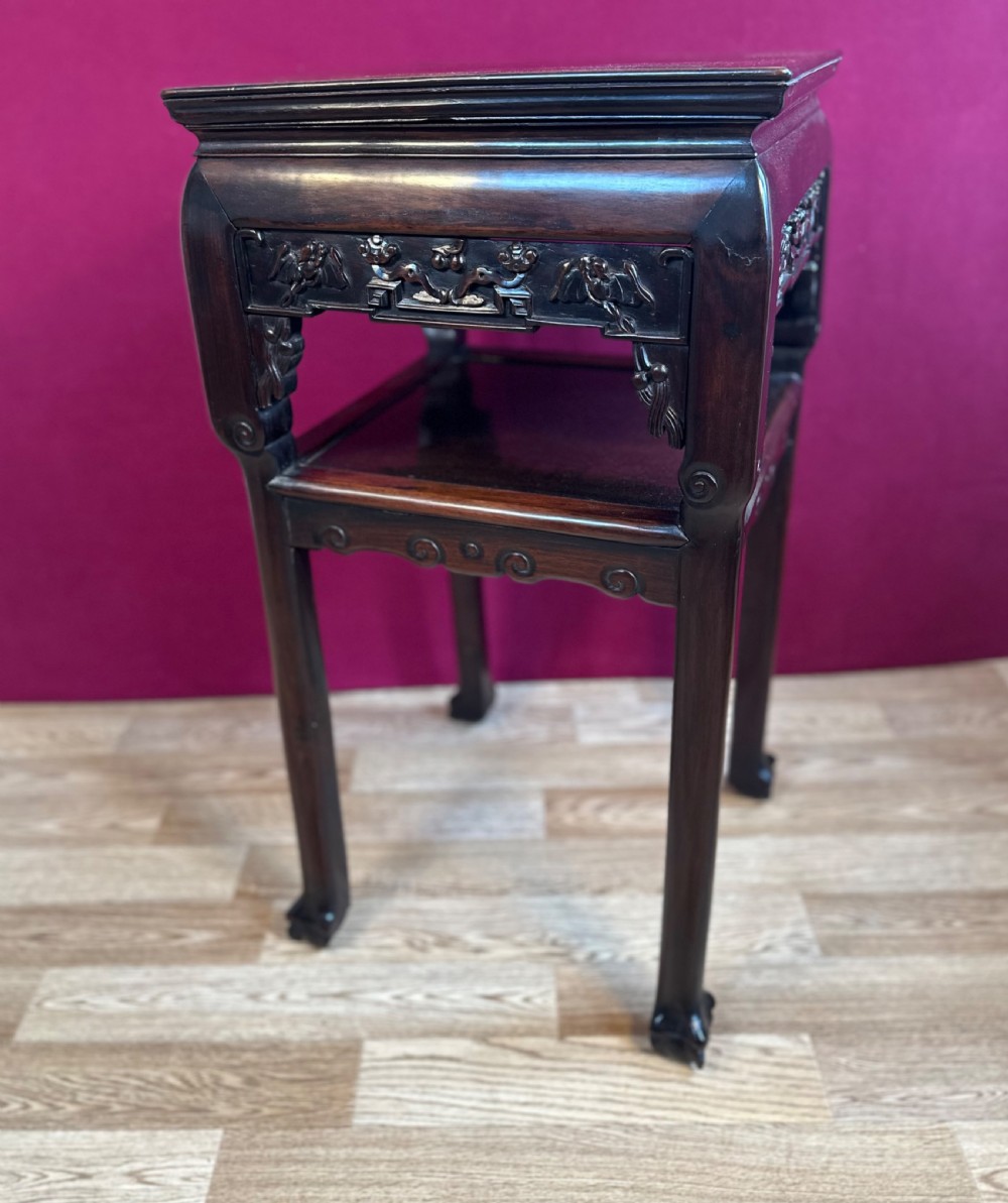 A dark hardwood late Qing dynasty Chinese pedestal table featuring carved openwork aprons, a lower tier shelf, and straight legs.