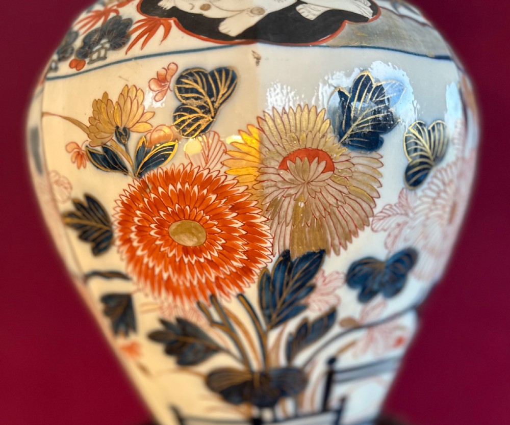 An octagonal porcelain covered vase decorated in Japanese Imari style with floral motifs and topped with a sculpted red foo dog finial. View VI