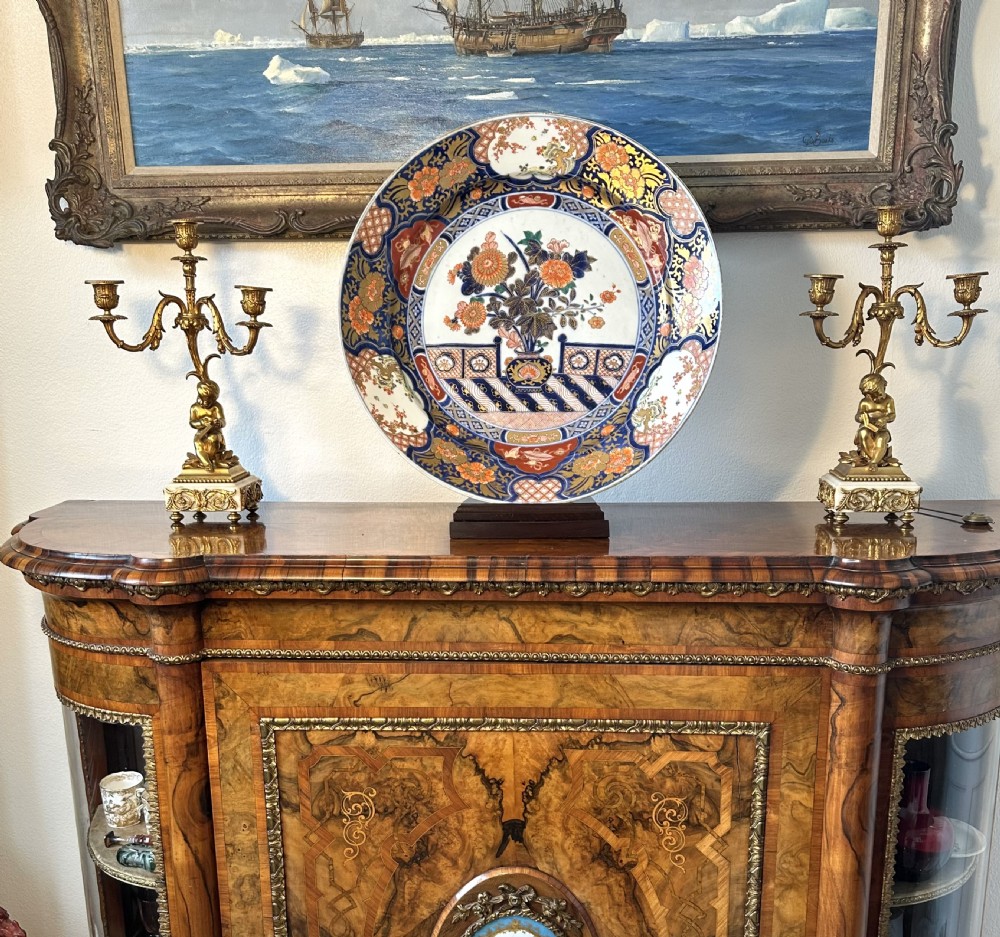 A circular Japanese Imari porcelain charger decorated with cobalt blue, iron red, and orange floral motifs around a central urn pattern. View XIII