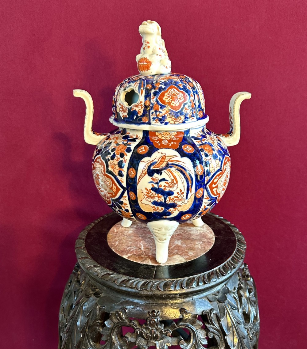 A Japanese Imari porcelain koro incense burner featuring a pierced domed lid topped with a shishi lion finial, twin side handles, tripod feet, and hand-painted blue and iron-red panels. View III