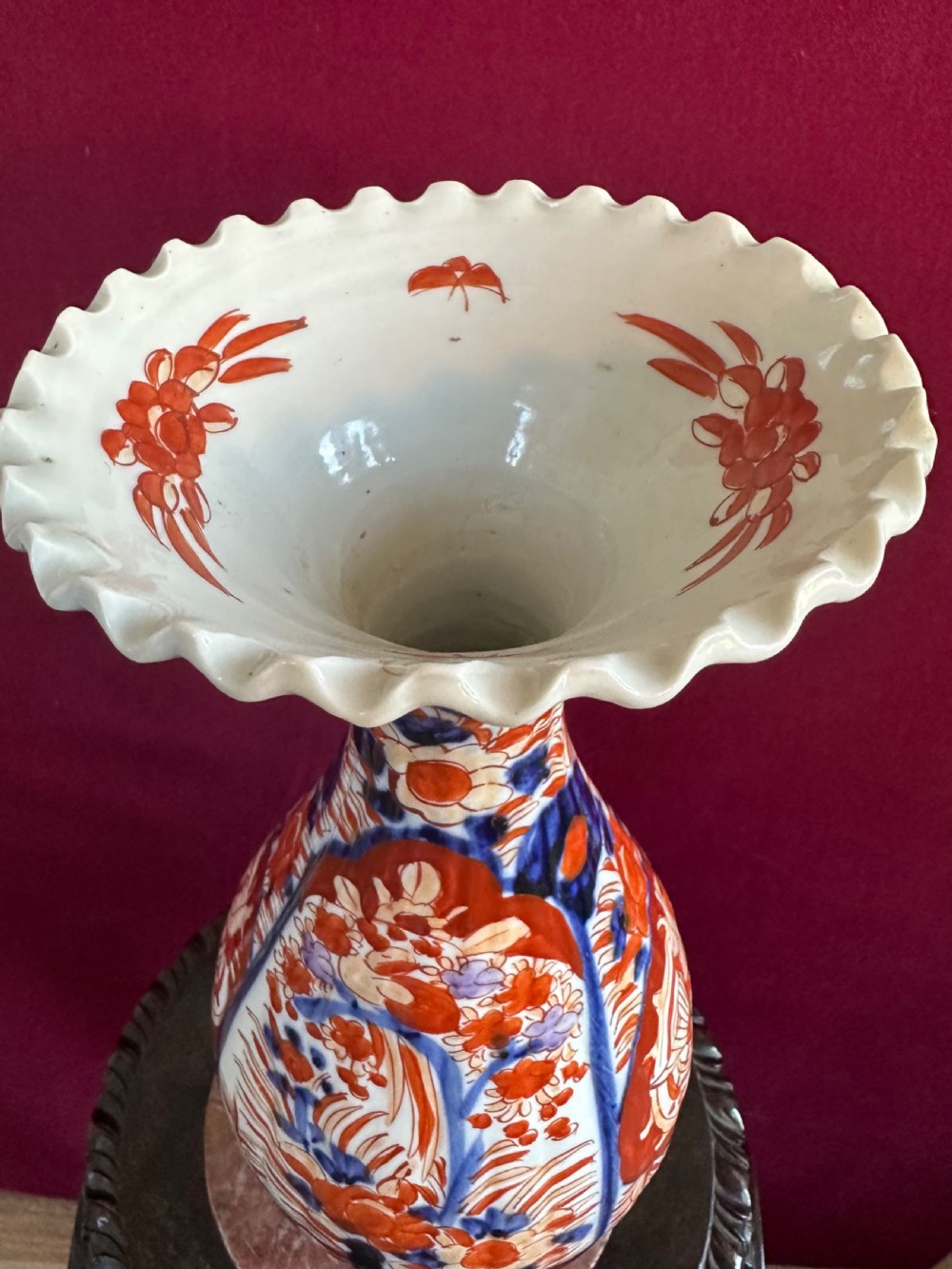 A pair of baluster-shaped Japanese Imari porcelain vases decorated with floral panels in cobalt blue and rust red, featuring crimped scalloped rims. View VI