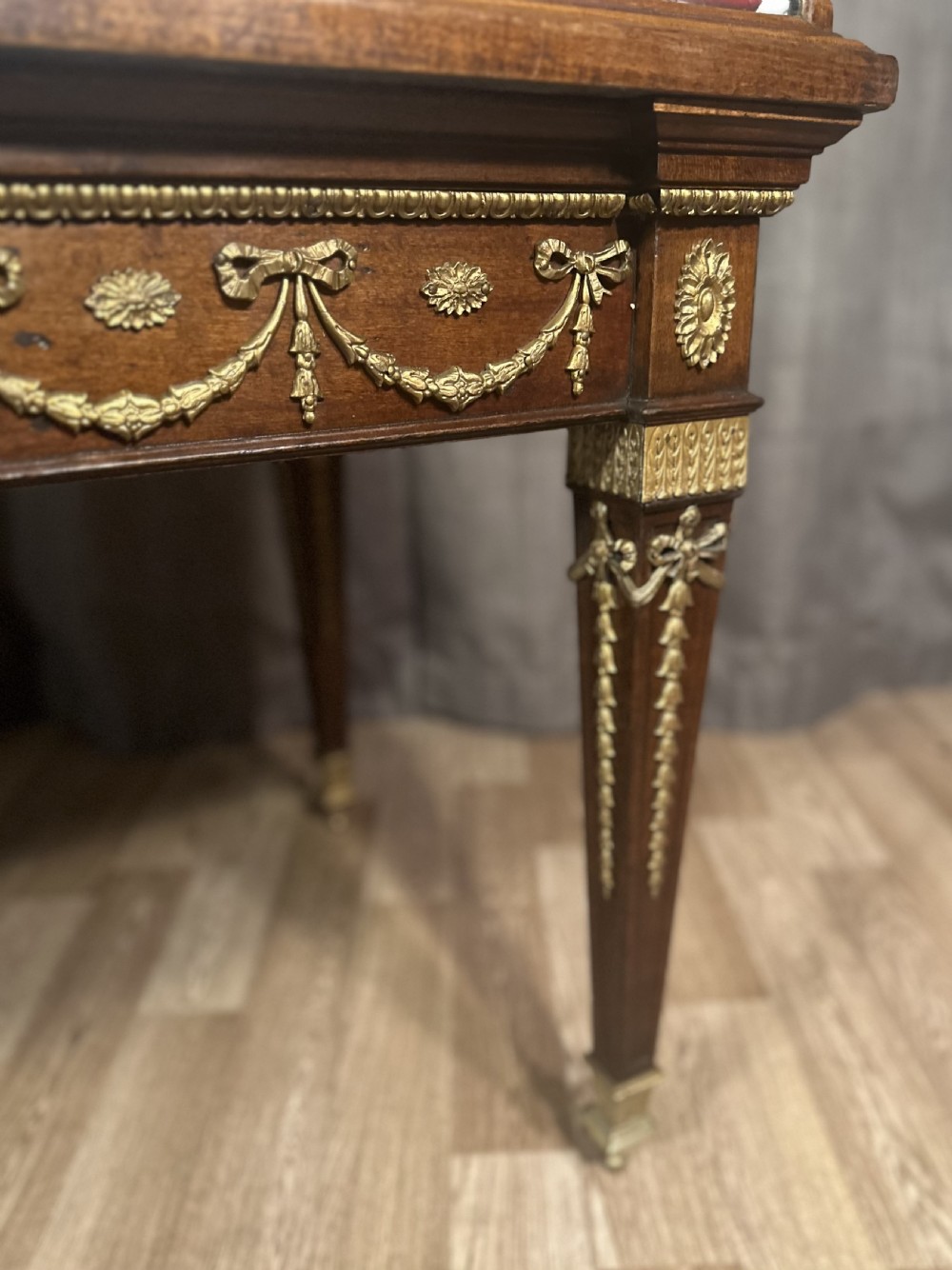 A late 19th-century mahogany table vitrine featuring clear glass panels, a red velvet interior base, tapered legs, and decorative gilt-bronze mounts. View XIII