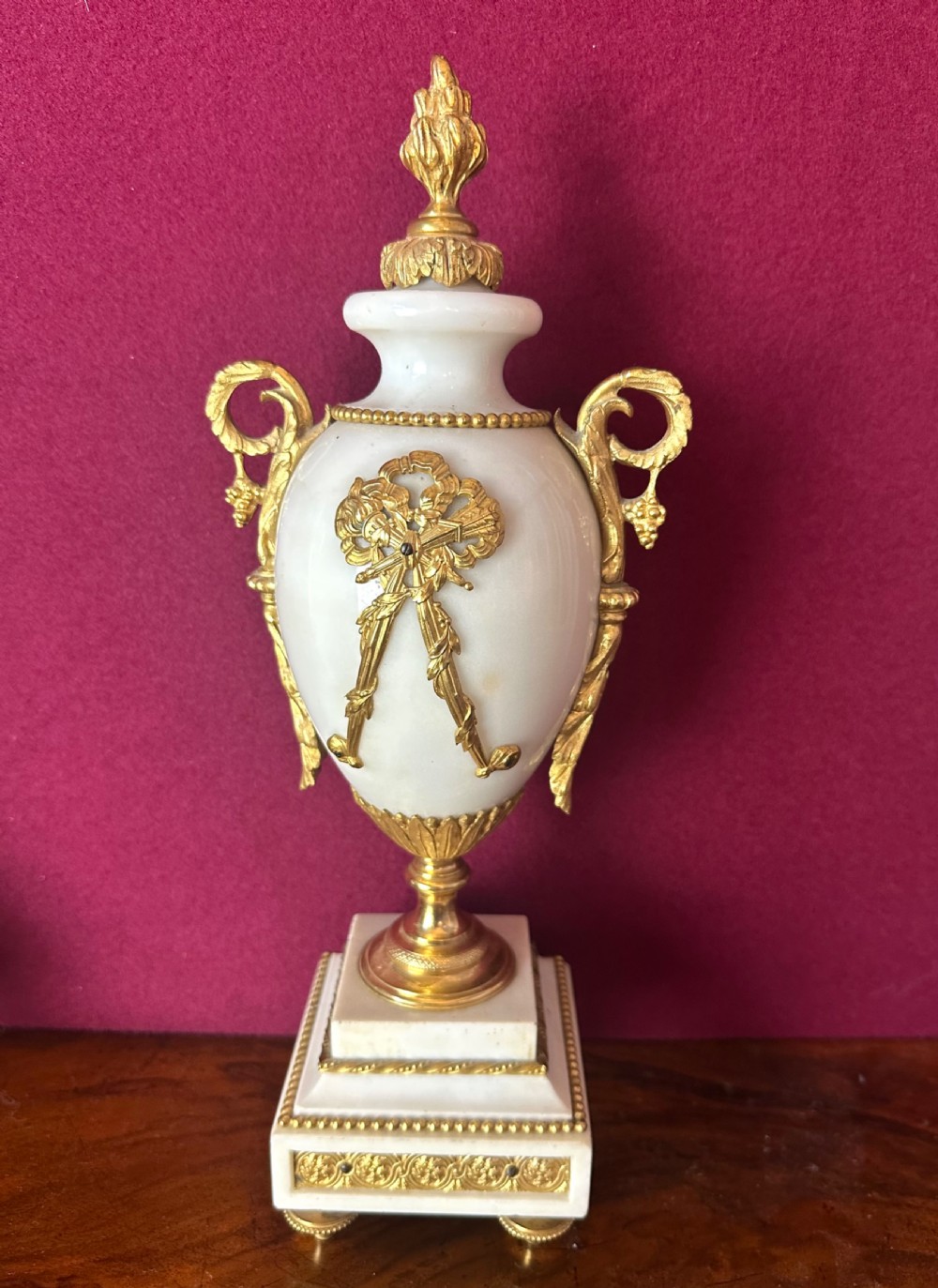 A late 19th-century French three-piece garniture set featuring a central white marble and gilt-bronze portico clock flanked by two matching ornamental urns. View II