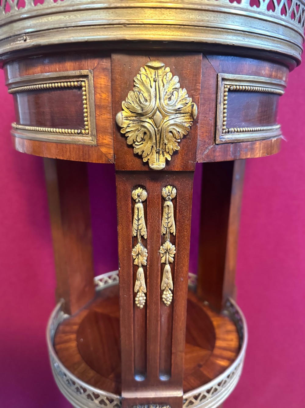 A tall, circular French style wine table with two tiers, brass gallery rims, and gilt-bronze leg mounts. View II