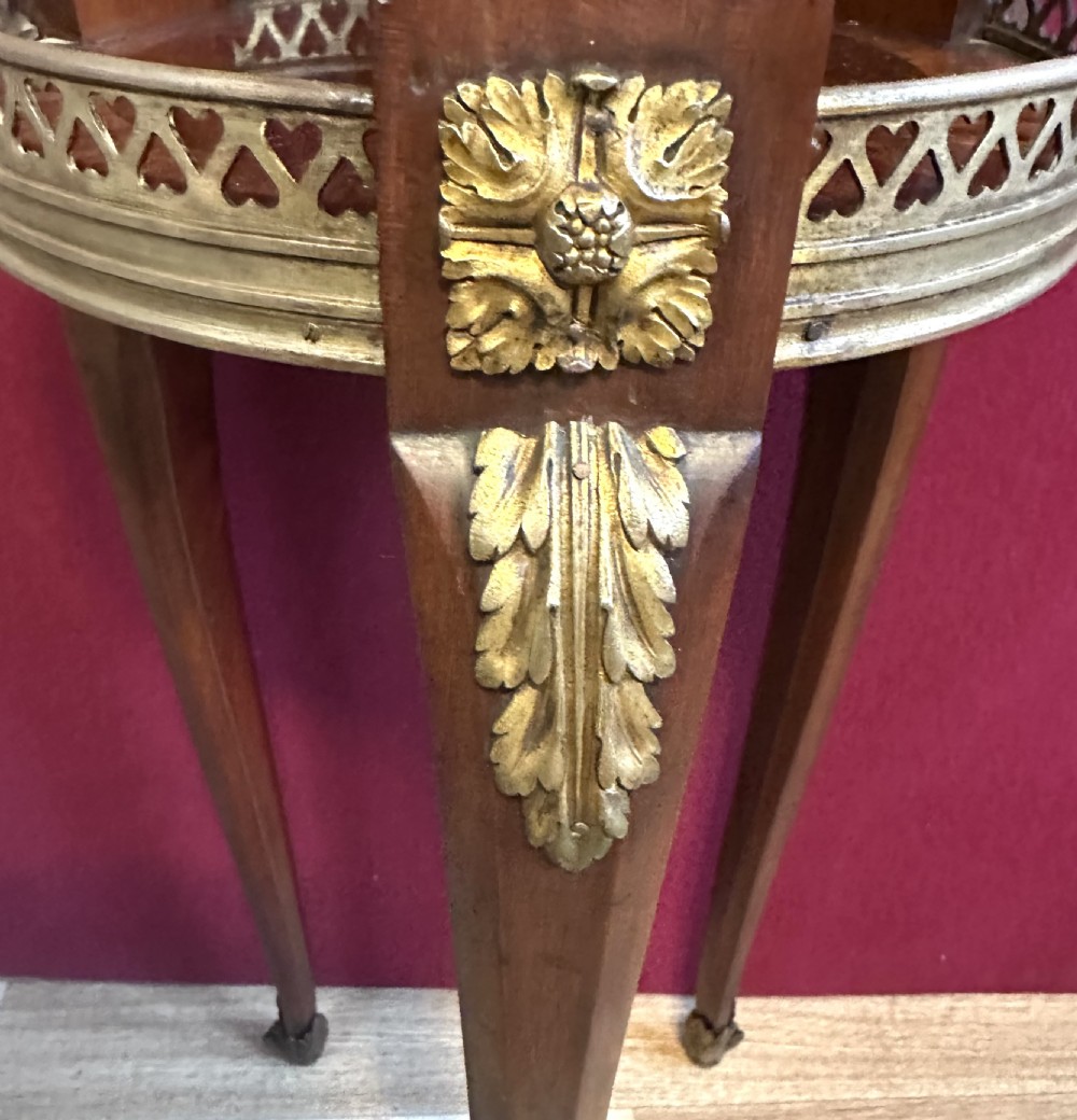 A tall, circular French style wine table with two tiers, brass gallery rims, and gilt-bronze leg mounts. View III