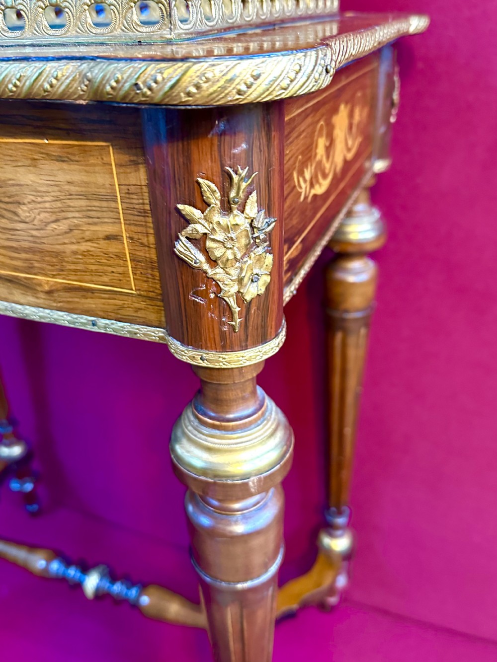A late nineteenth-century French style marquetry side table featuring floral inlays, a pierced brass gallery top, turned legs, and a shaped lower stretcher. View IX