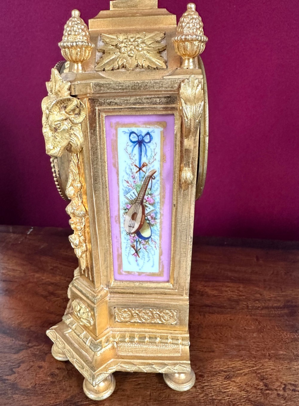 A late 19th-century French gilt bronze mantel clock featuring pink hand-painted porcelain panels and an urn finial. View II