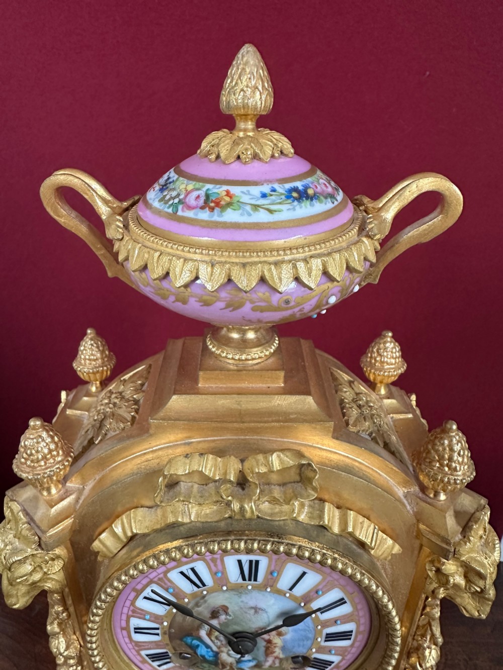 A late 19th-century French gilt bronze mantel clock featuring pink hand-painted porcelain panels and an urn finial. View IV
